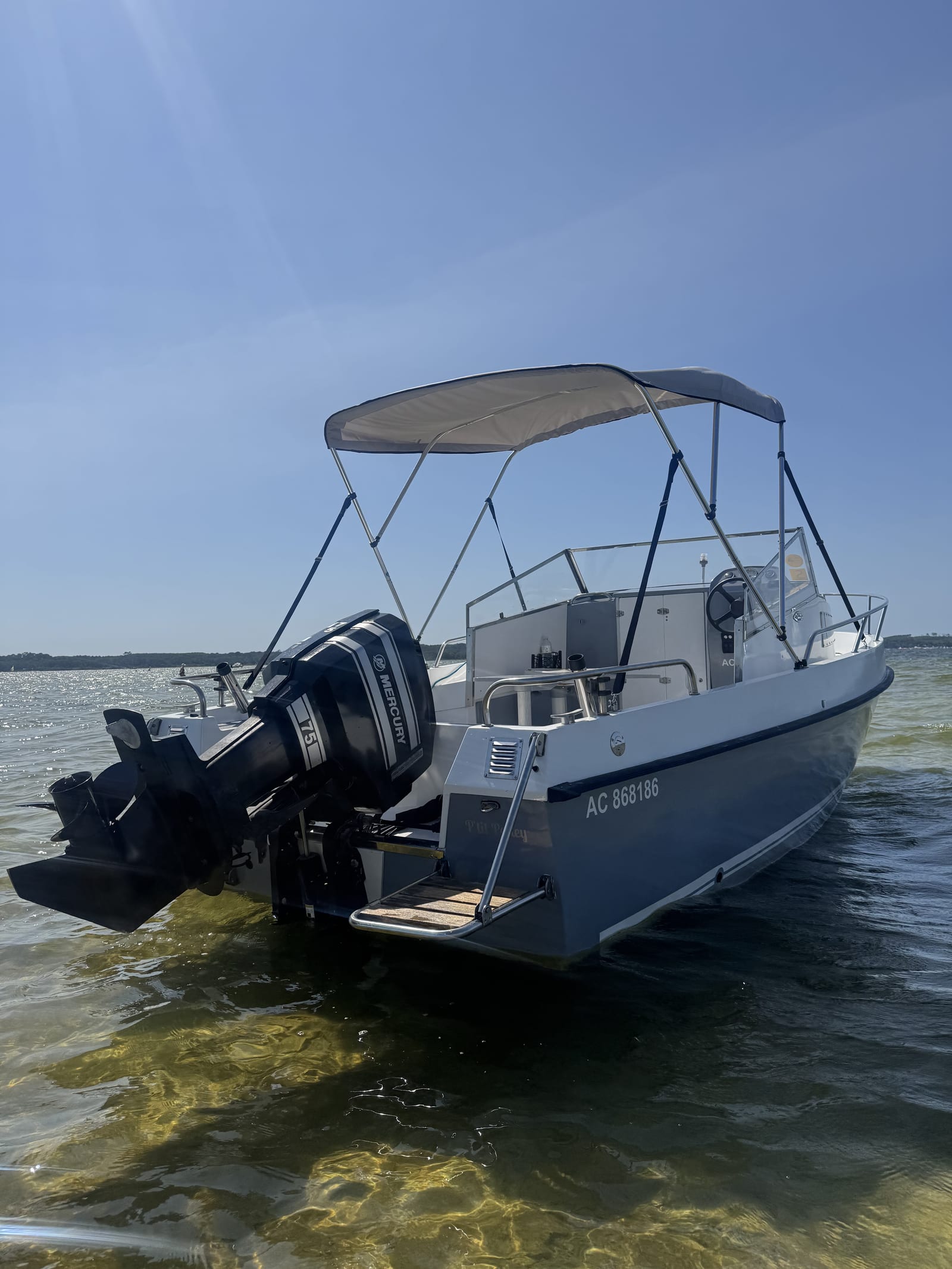 Le taud pare-soleil (bimini) déployé à l'arrière du bateau, vu depuis le lac