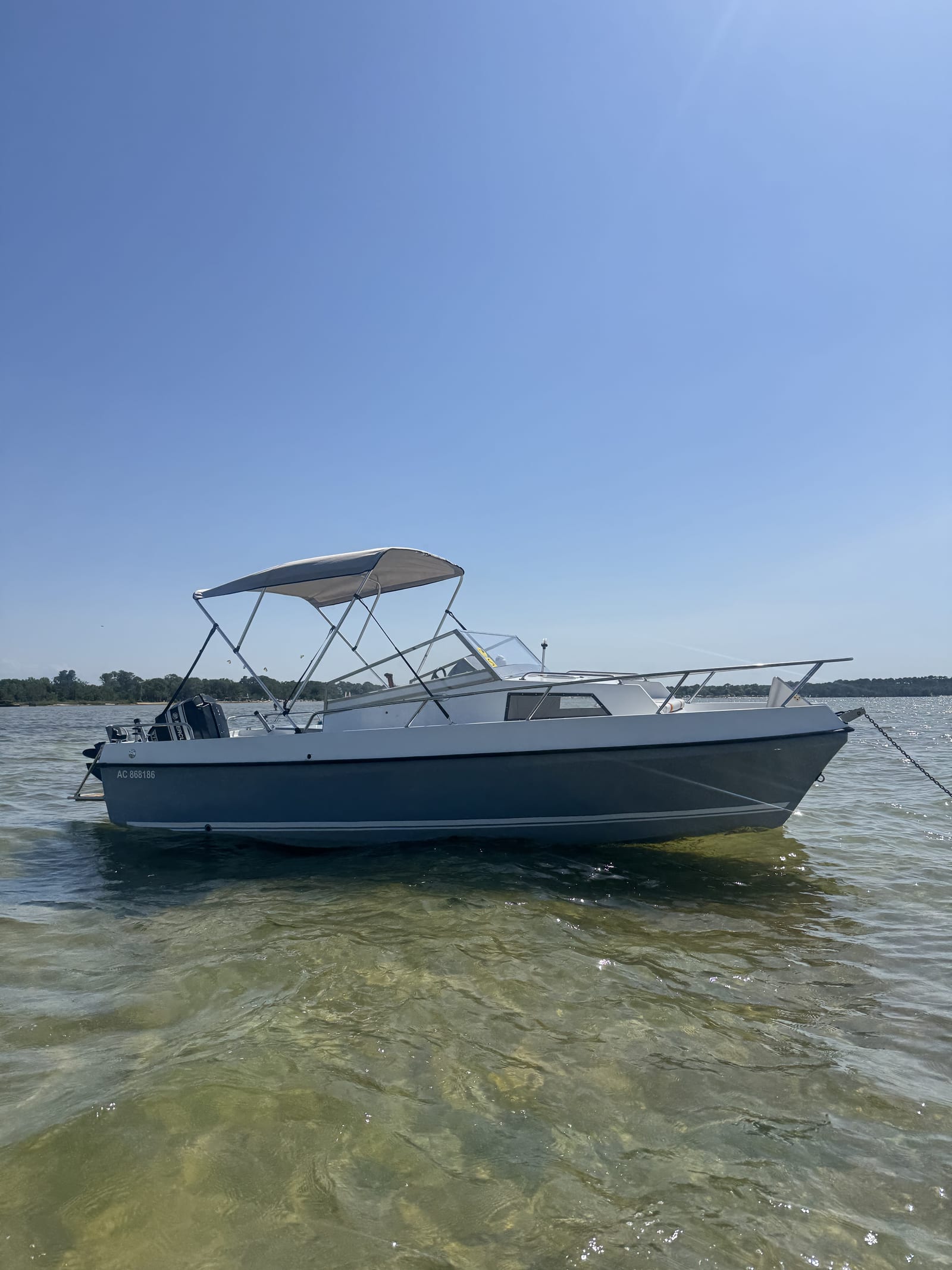 Le bateau P'tit Poney avec son taud pare-soleil (bimini) déployé, amarré sur le lac de Biscarrosse-Parentis