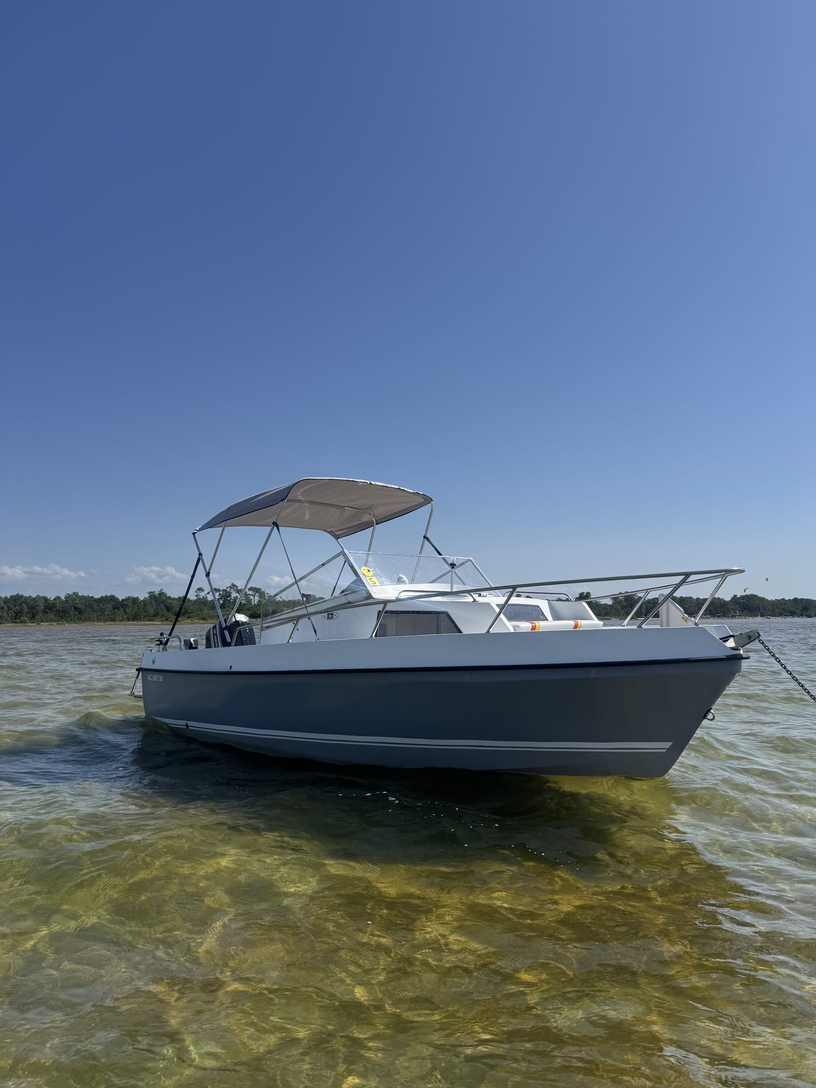 Le bateau P'tit Poney avec son taud pare-soleil (bimini) déployé au-dessus du poste de pilotage